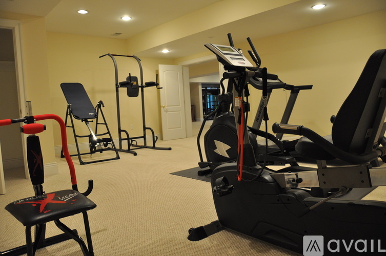 A gym with a variety of equipment including a leg press machine, a chest press machine, and a treadmill.