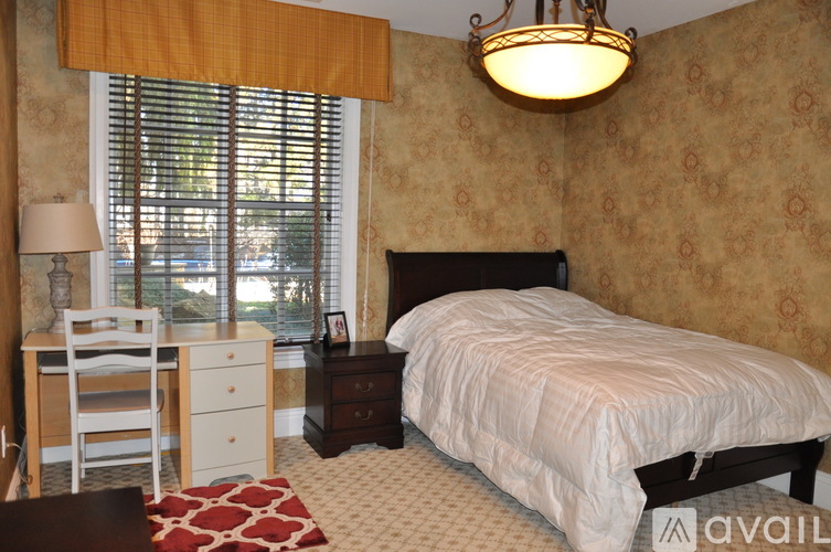 A bedroom with a large bed and a dresser with a mirror.