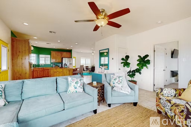 A living room with a blue couch and a ceiling fan.