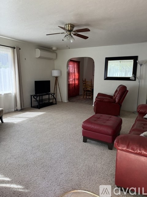 A living room with red leather furniture and a flat screen TV.