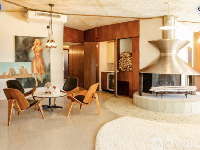 A living room with a fireplace and a painting of a woman.