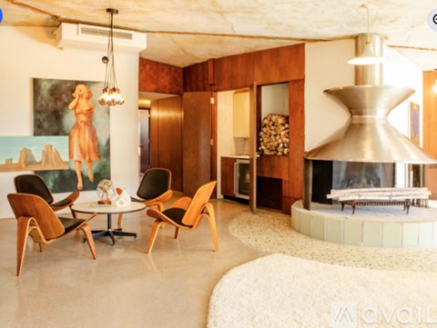 A living room with a fireplace and a painting of a woman.