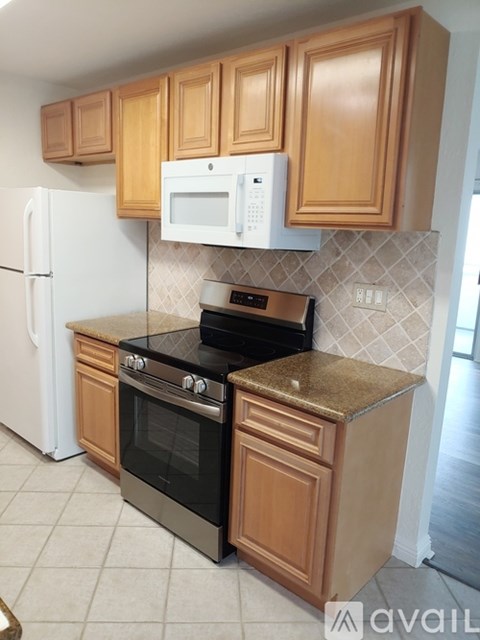 A kitchen with brown cabinets and a black stove top oven.