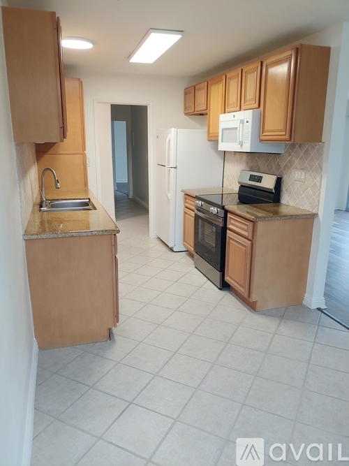 A kitchen with wooden cabinets and appliances.