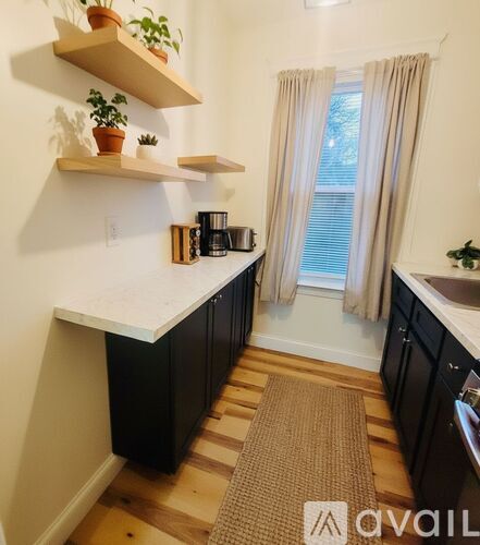 A kitchen with black cabinets and a white countertop.