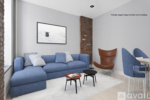 A living room with a blue couch and a painting of a moose on the wall.