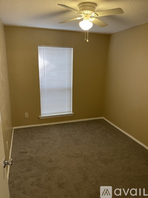 A room with a ceiling fan and carpeted floor.