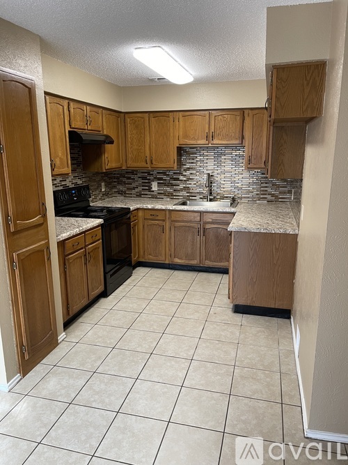A kitchen with wooden cabinets and a black stove top oven.