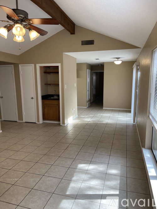 A spacious room with a ceiling fan and tiled flooring.