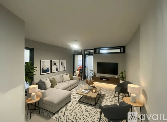 A modern living room with a grey sofa, a coffee table, and a television.