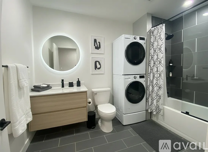 A bathroom with a toilet, sink, mirror, and a washing machine.