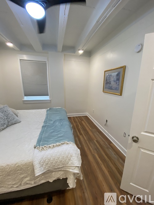 A bedroom with a bed and a picture on the wall.