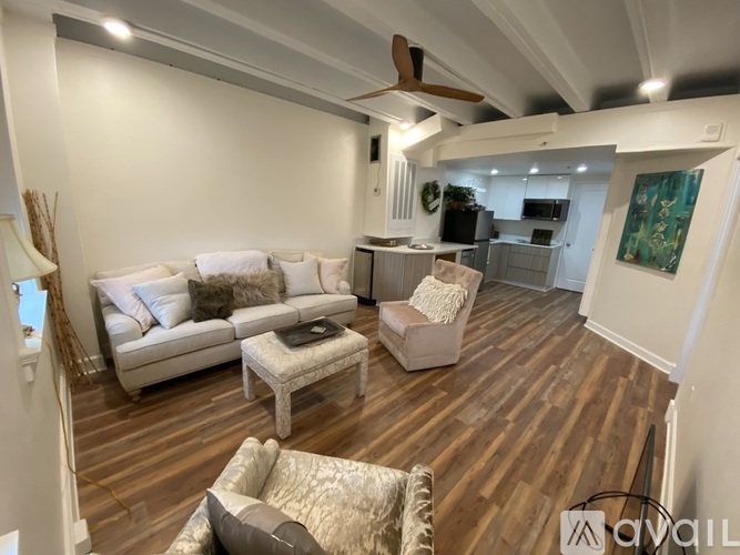 A living room with a white couch and a wooden floor.