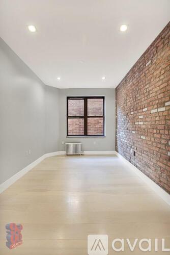A room with a brick wall and a window.