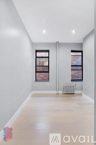A spacious room with a window and a radiator on the floor.