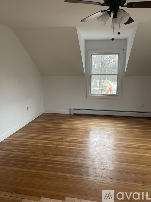A room with a ceiling fan and a window.