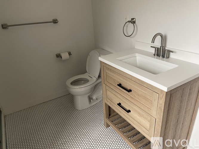 A white toilet sits in a bathroom next to a sink.