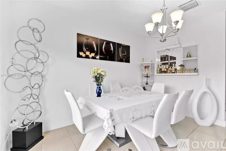 A modern dining room with a white table and chairs.