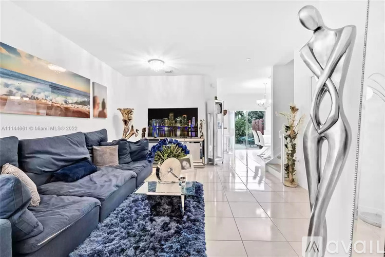 A modern living room with a grey sofa and a large abstract sculpture.