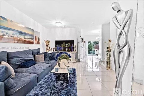 A modern living room with a grey sofa and a large abstract sculpture.