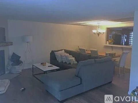 A living room with a grey couch and a glass coffee table.