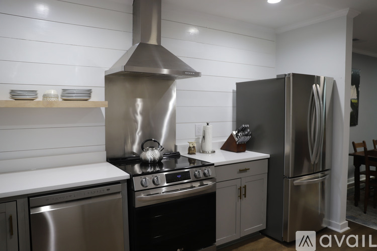 A modern kitchen with stainless steel appliances and a range hood.