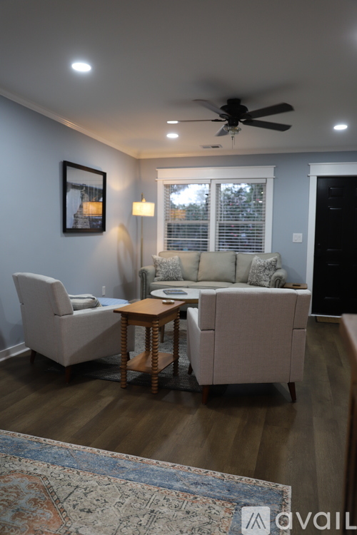 A living room with a couch, chair, and rug.