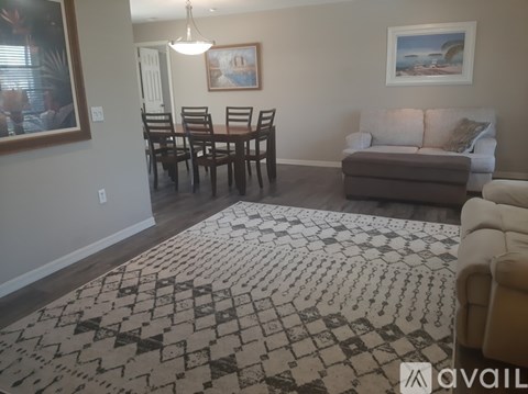 A living room with a brown rug and a brown couch.