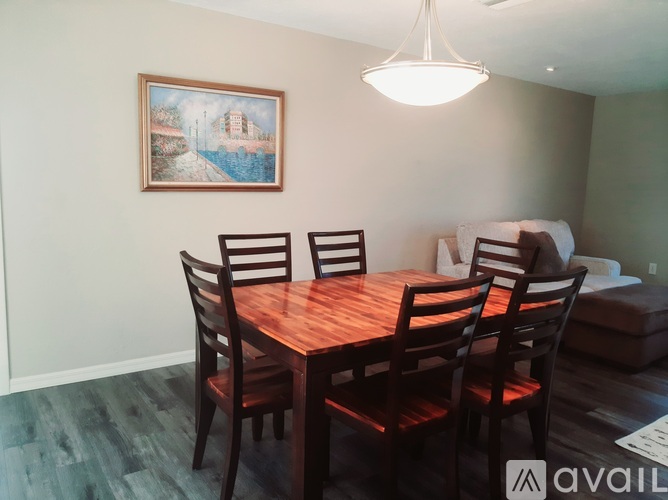 A dining room with a wooden table and chairs.