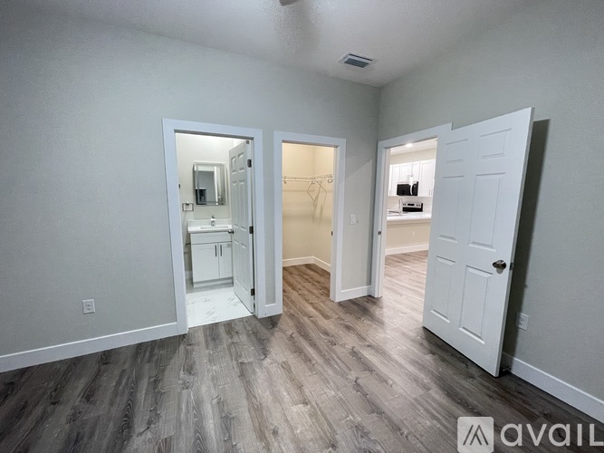 A room with a white door and a mirror on the wall.