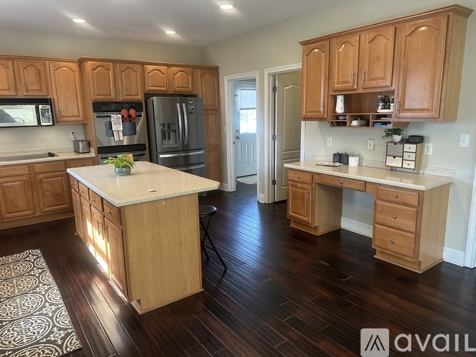 A kitchen with wooden cabinets and a white island.