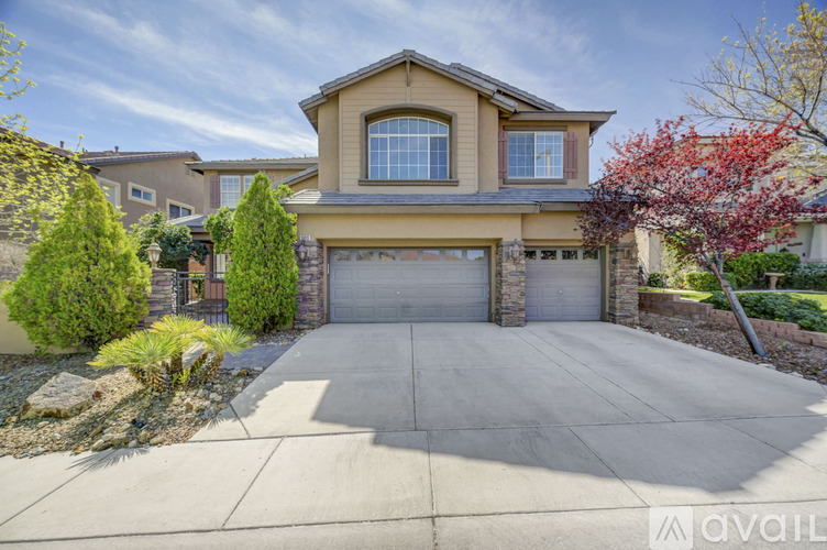 A house with a garage and a driveway in front of it.