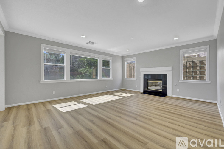 A spacious living room with a fireplace and hardwood flooring.