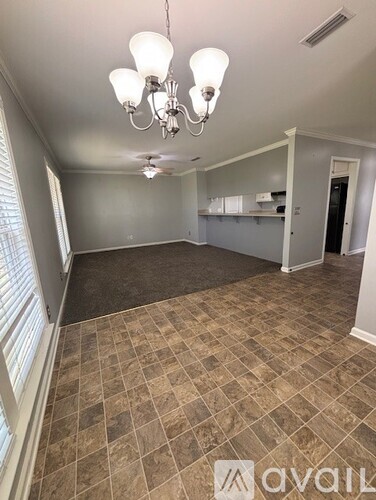 A room with a tiled floor and a chandelier hanging from the ceiling.