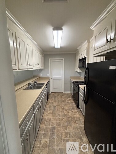 A kitchen with black appliances and white cabinets.