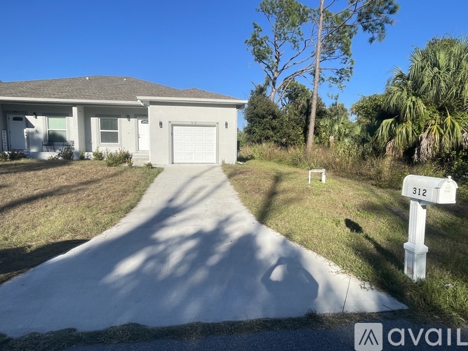 A house with a driveway and a mailbox with the number 312 on it.