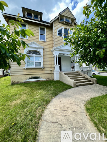 A two-story house with a front porch and a staircase leading to the front door.