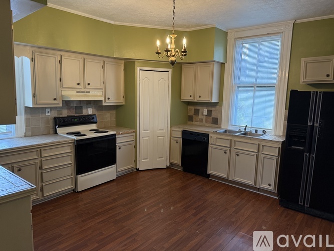 A kitchen with wooden floors and white cabinets.