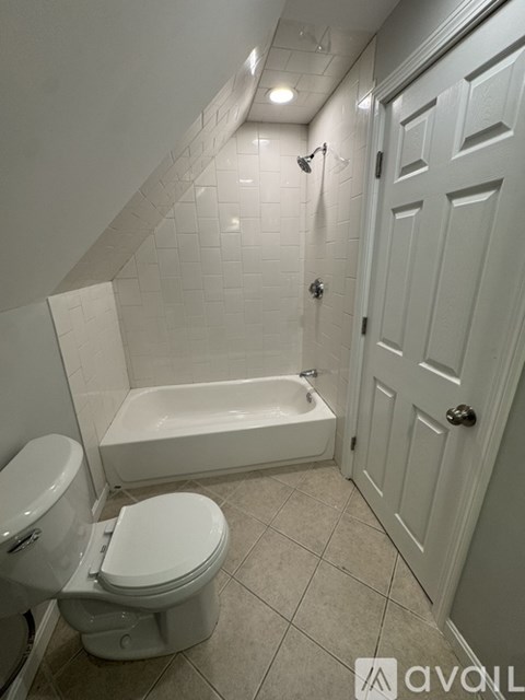 A white toilet and bathtub in a bathroom.