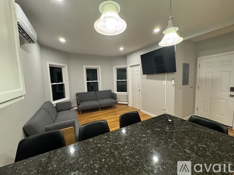 A living room with a black granite table and grey sofas.
