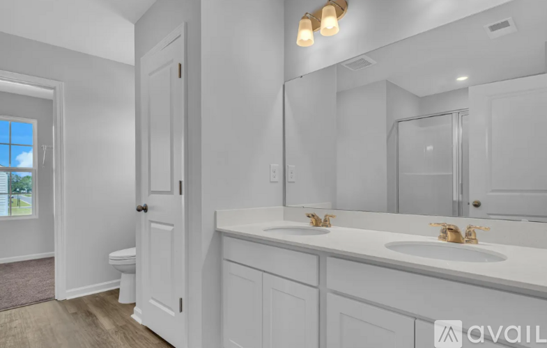 A bathroom with a white sink and a white toilet.