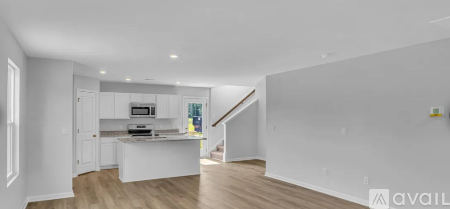 A spacious kitchen with white cabinets and a central island.