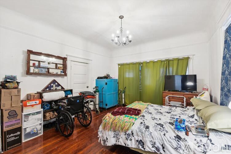 A bedroom with a bed, a wheelchair, and boxes of supplies.