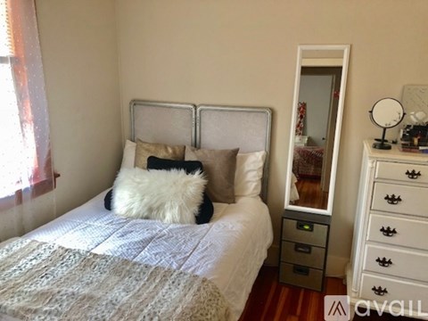 A bedroom with a bed, a dresser, and a mirror.
