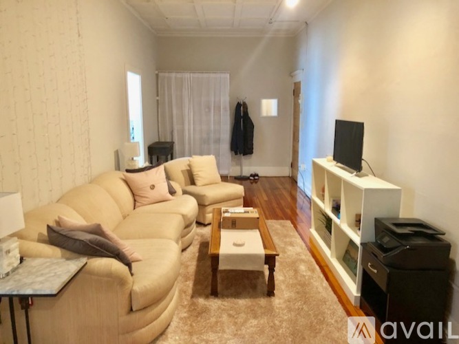 A living room with a tan couch and a white entertainment center.