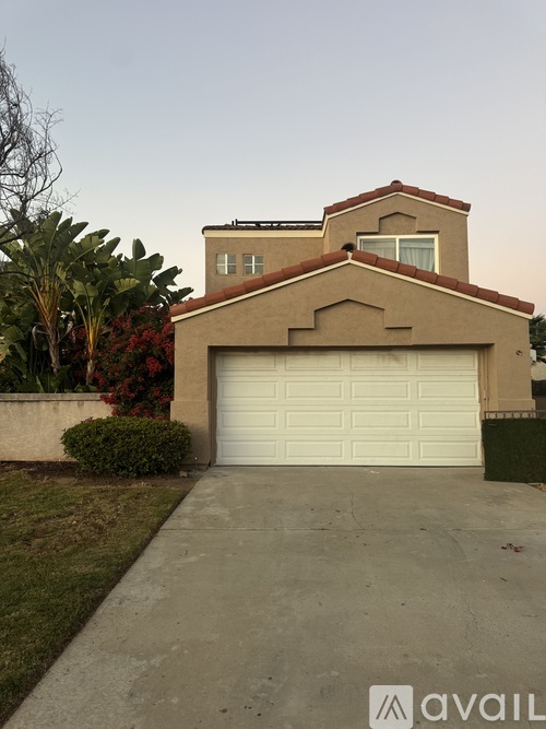 A house with a white garage door and a brown roof.