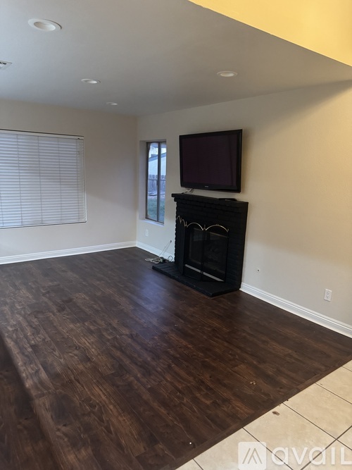 A living room with a fireplace and a television.