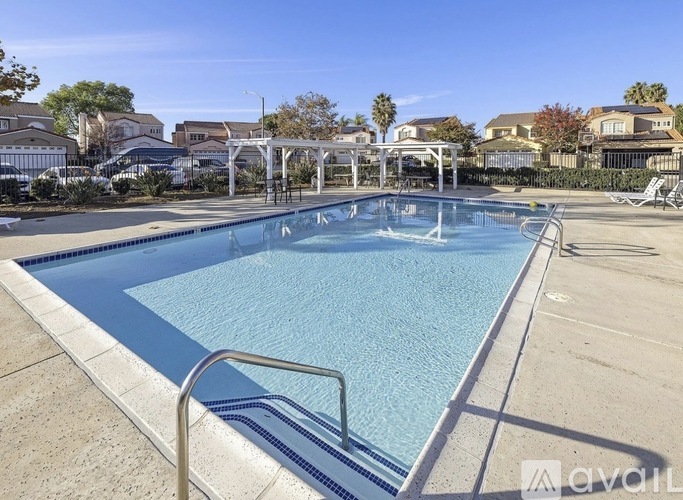 A large outdoor swimming pool with a metal ladder on the side.