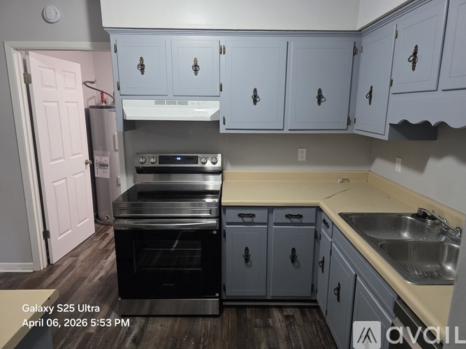 A kitchen with a black oven and a white fridge.