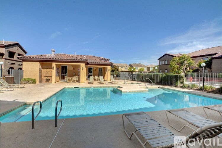 A pool with a slide and a building behind it.